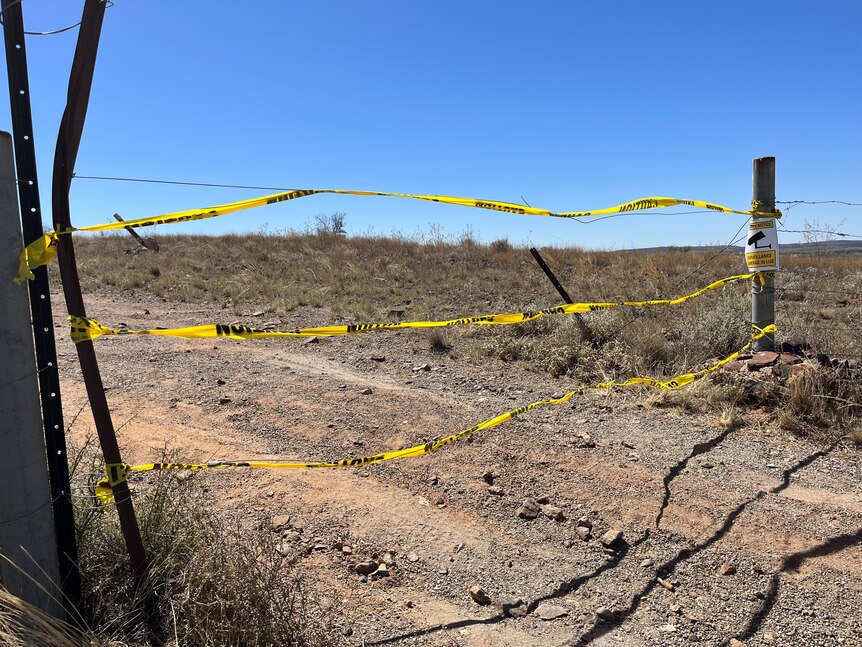 A wire fence with yellow tape across the front