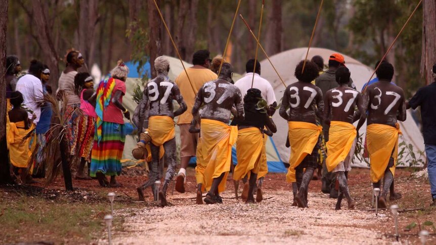 Indigenous dancers display the number 37