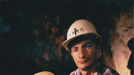 Ilias Katsapouikidis sits in mine shaft holding smashed helmet