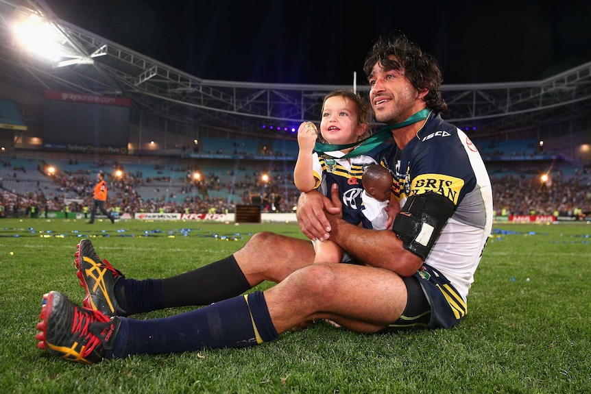 Johnathan Thurston sits with daughter on the rugby field