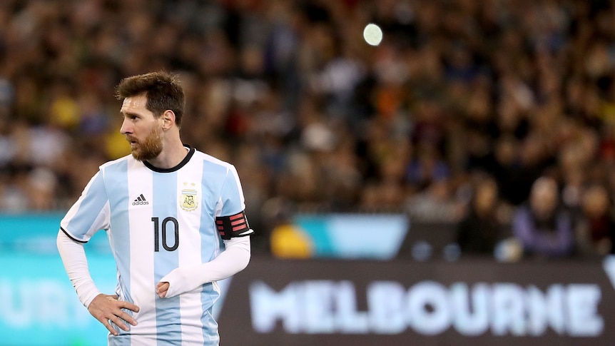 Lionel Messi looks off to one side wearing an Argentina kit