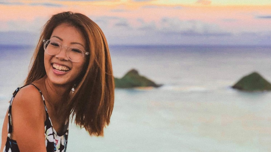 Vivian Wong sits on a cliff edge overlooking a view to depict taking an adult gap year.
