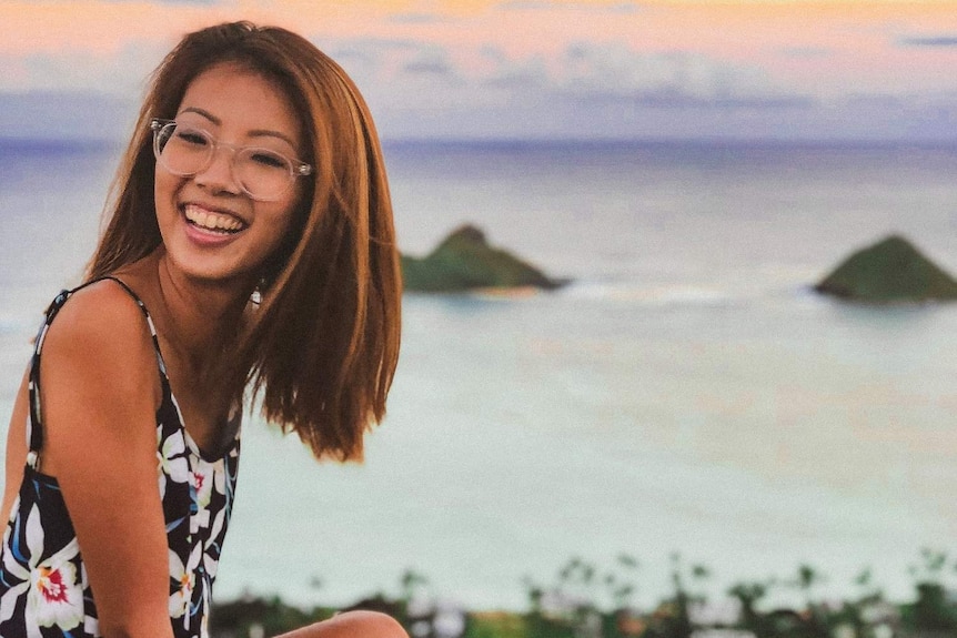 Vivian Wong sits on a cliff edge overlooking a view to depict taking an adult gap year.