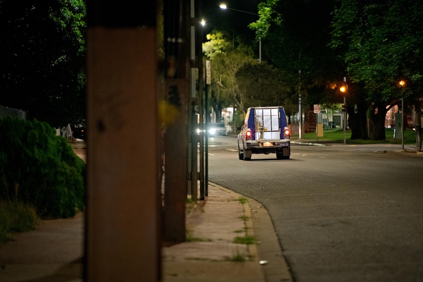 A police car drives away in alice springs at night. 