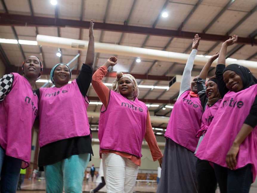Women from Stand Up do 'hands in' before an indoor soccer match