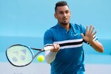 Nick Kyrgios hits a forehand shot with his left land raised in front of him