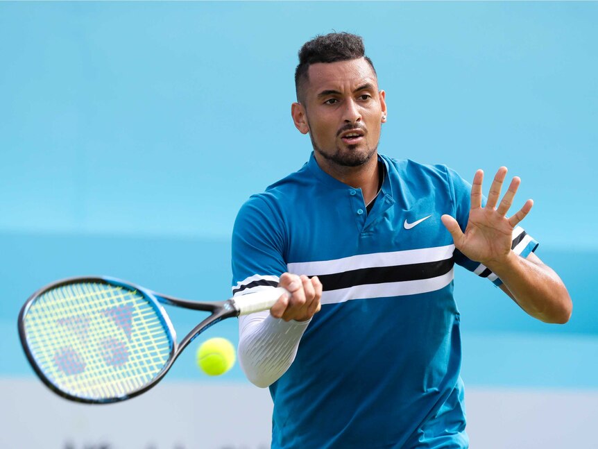 Nick Kyrgios hits a forehand shot with his left land raised in front of him