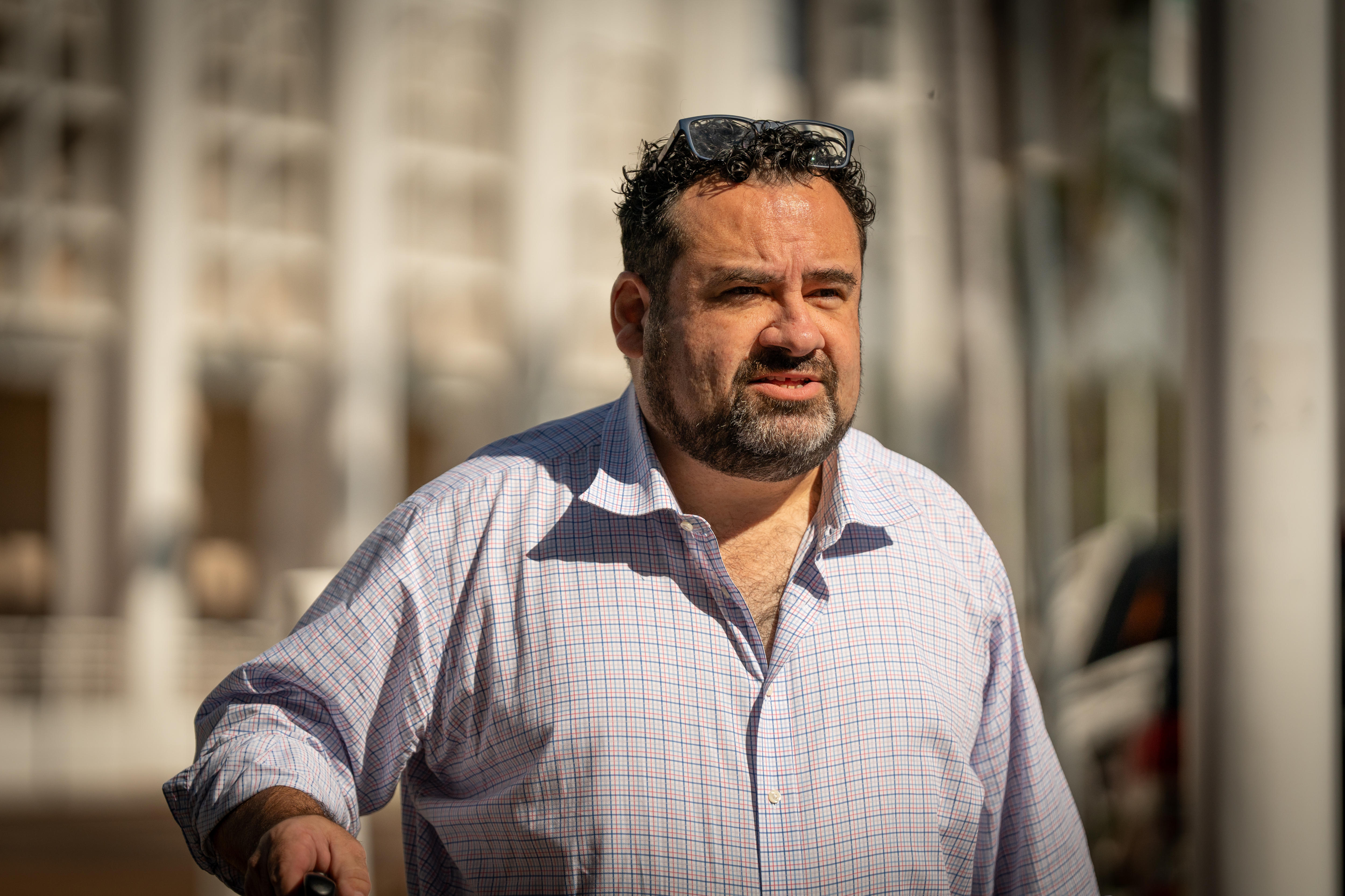 A man wearing a chequered shirt wearing glasses on his head.
