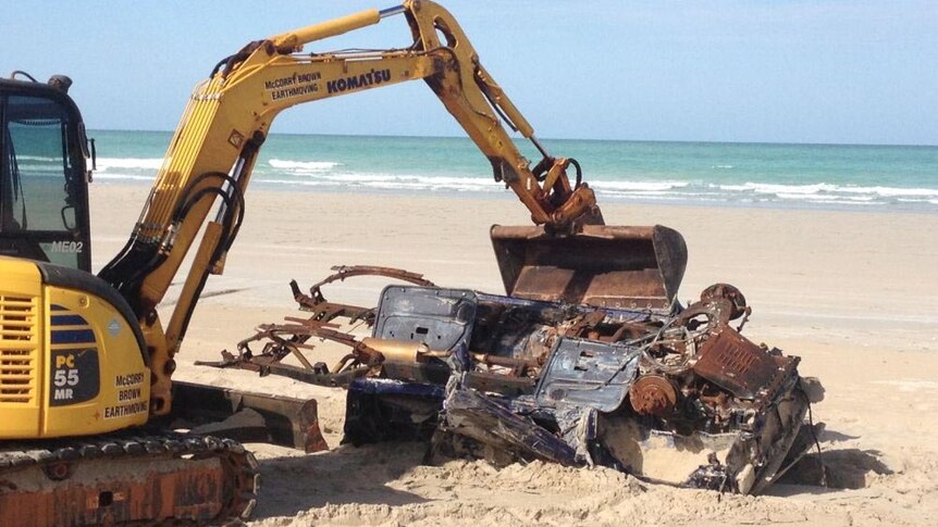 A backhoe removes a vehicle from Coconut Wells