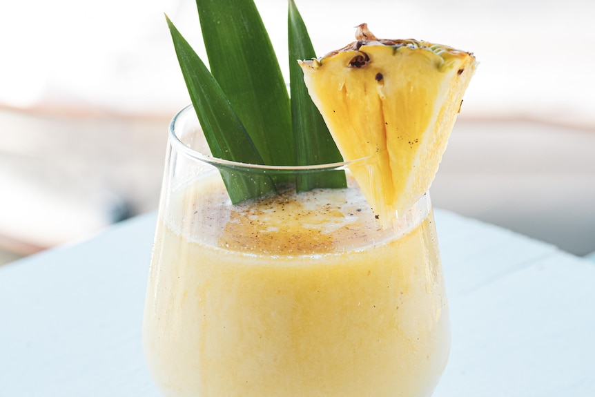 Pineapple smoothie garnished with a slice of pineapple