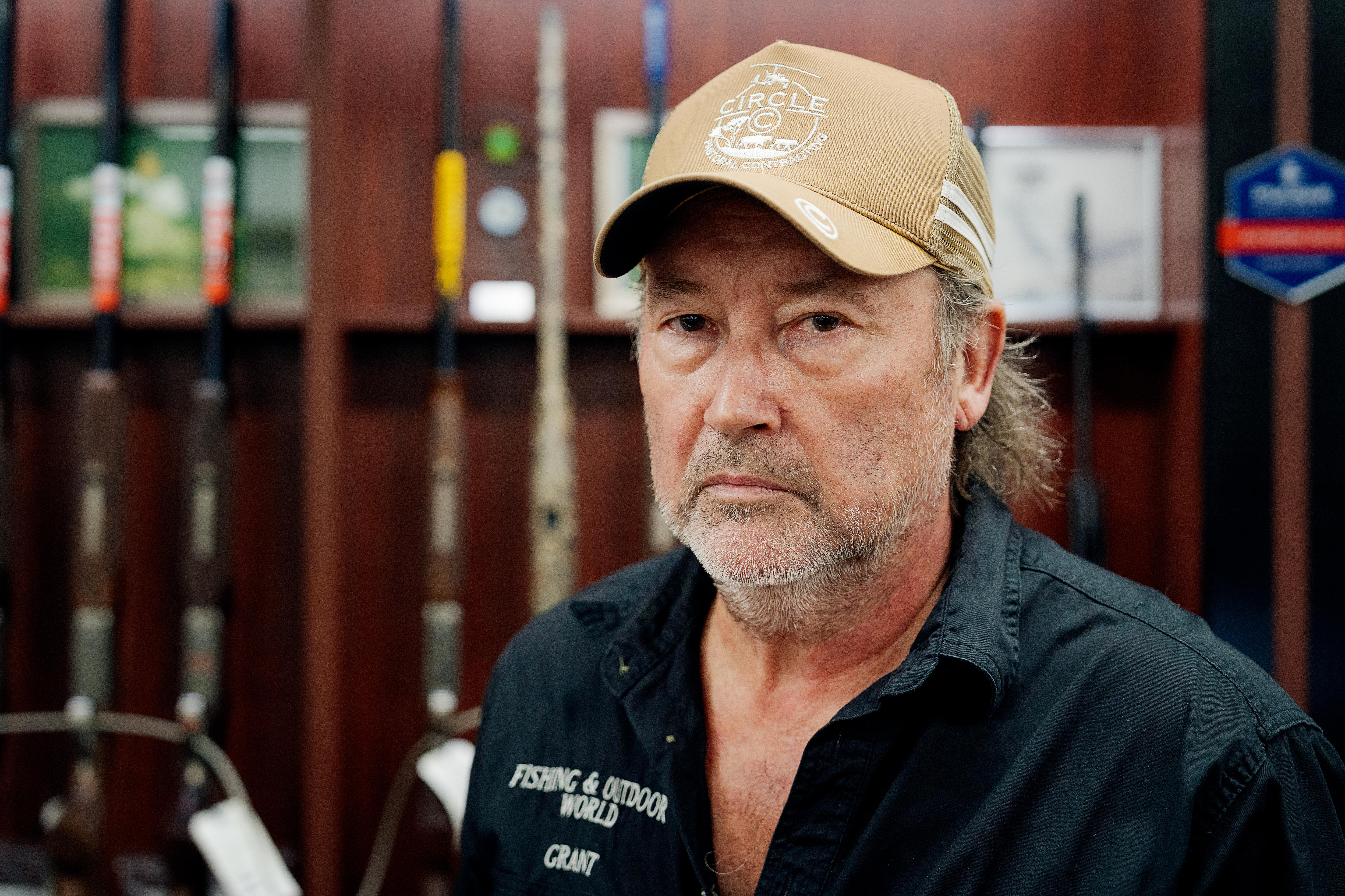 Homem com chapéu de caminhoneiro fica na frente de armas na loja 