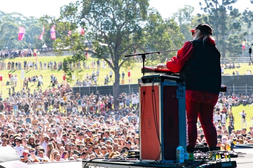 A woman behind a podium in front of a microphone in front of a crowd