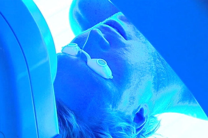 A man in a tanning bed