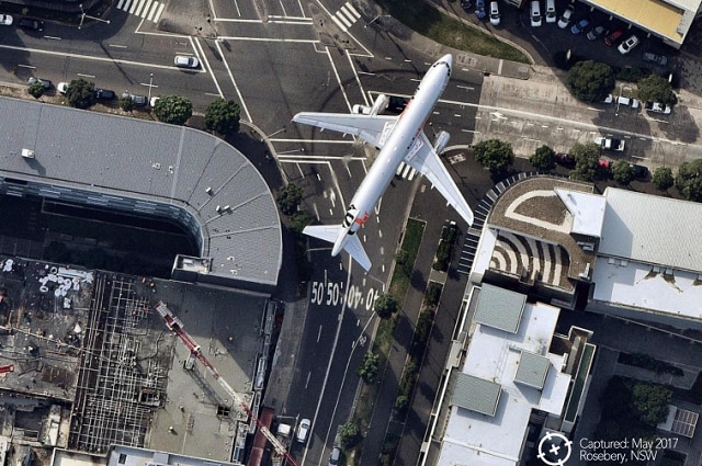 An image captured by Nearmap of a Jetstar aircraft flying over an industrial complex in Rosebery, NSW