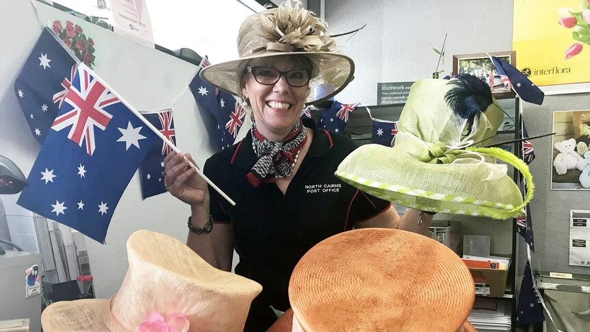 Melissa Harwood shows off her selection of formal hats and Australian flags for the royal visit of Prince Charles to Cairns.