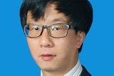 A headshot of a young Chinese man with glasses