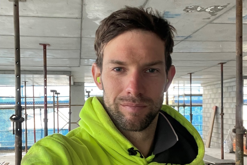 Man in fluoro green hoodie on work site