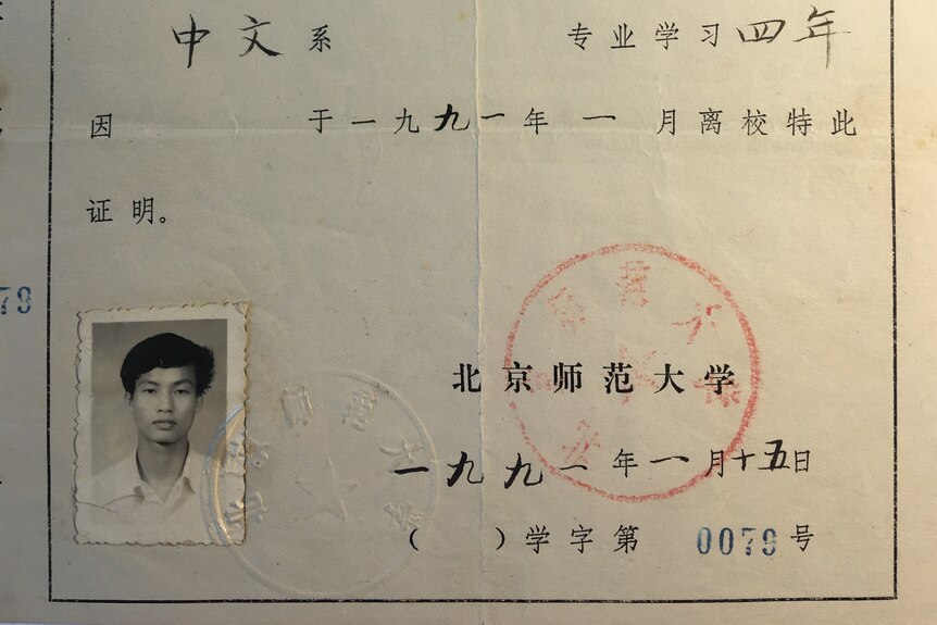 A piece of paper with Chinese characters and a black and white headshot of a student,