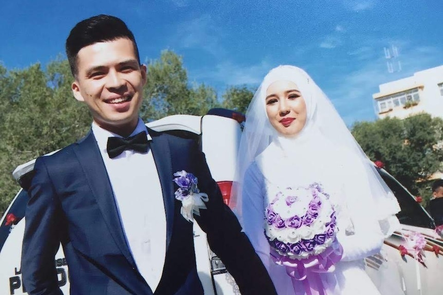 A man and a woman in wedding dresses smiling