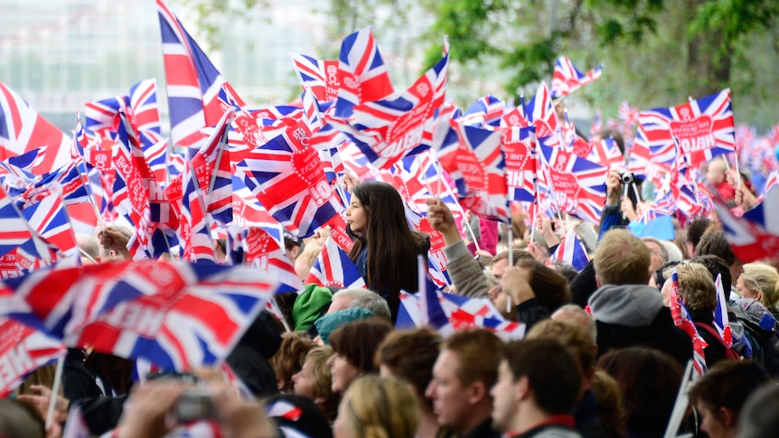 People line the banks waving Britain's Union flags