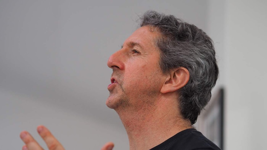 A close up photo of a man's face while talking