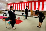 two students in black uniforms stand during a ceremony at Yumoto Junior High School