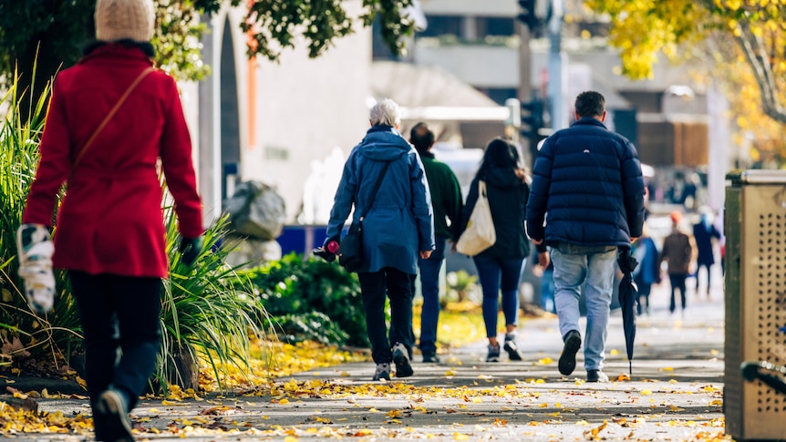 The backs of Melburnians walking in winter.