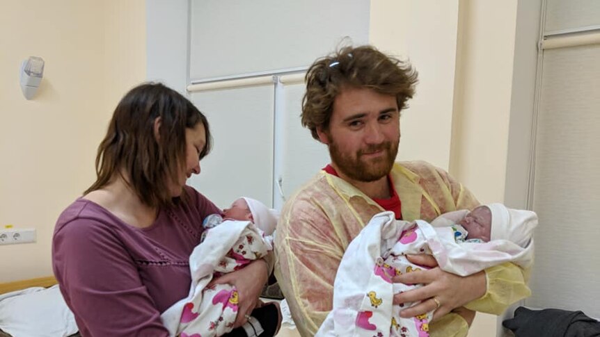 Marie and Antony Williams holding their newborn twins in the hospital room