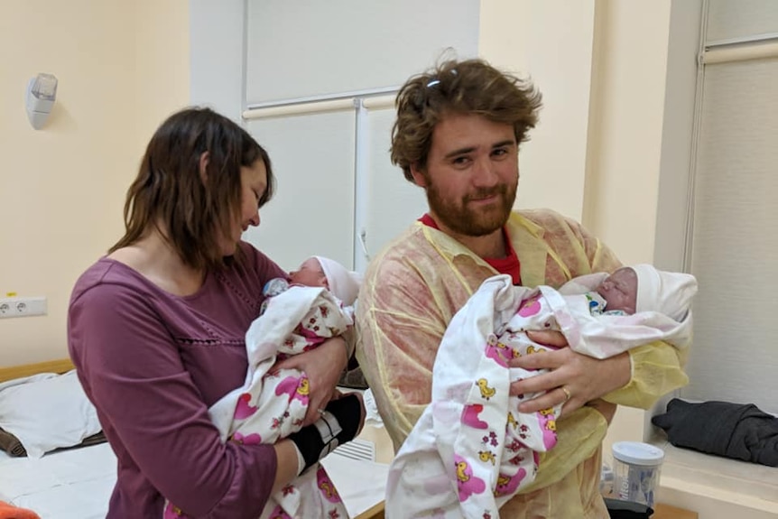 Marie and Antony Williams holding their newborn twins in the hospital room