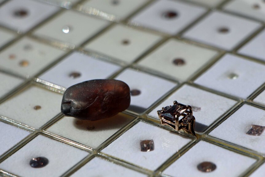 A zircon rock and polished zircon stones in individual cases