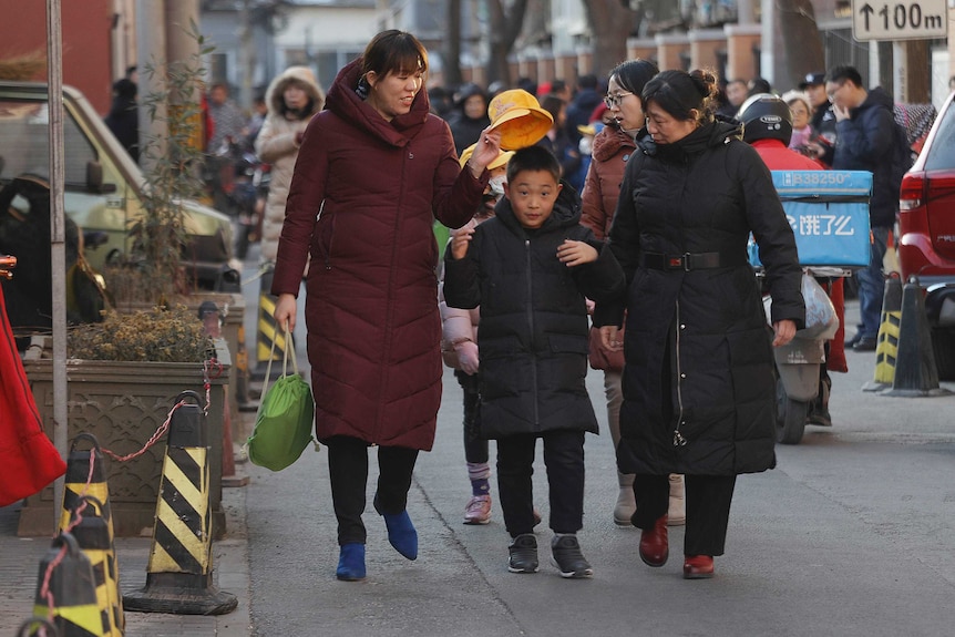 Women and children leave the Beijing No. 1 Affiliated Elementary School of Xuanwu Normal School following an attack in Beijing.