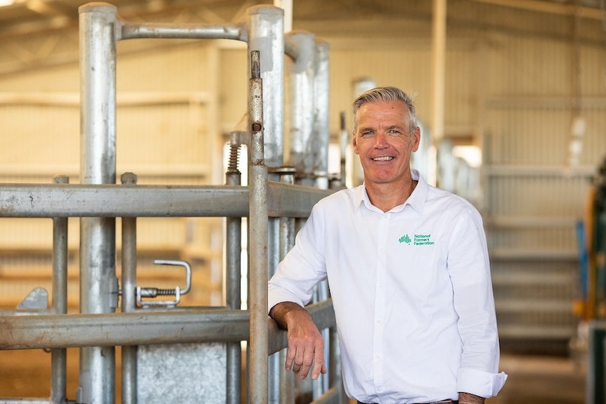 Man standing in front of some cattle yards.