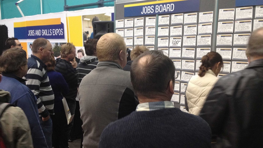 People check jobs boards at an expo in Devonport.