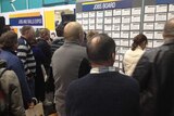 People check jobs boards at an expo in Devonport.
