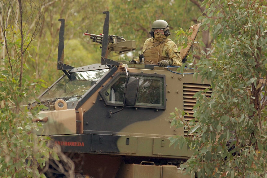 An Army Reservist in a Bushmaster troop carrier in bushland