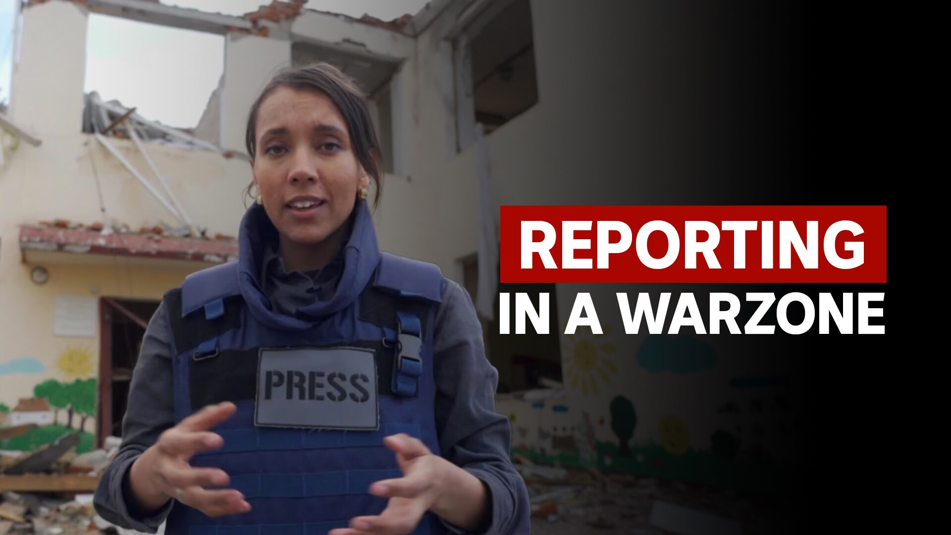 ABC reporter Isabella Higgins reports in front of a bombed building wearing a press badged protective vest.