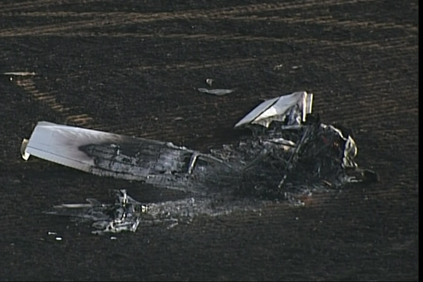 The charred remains of a small plane in a paddock