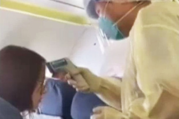 Video still circulating on Chinese social media shows a medic checking temperatures of a passenger on Wuhan to Macao flight.