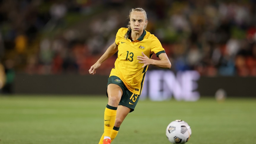 Australian soccer player kicks the ball