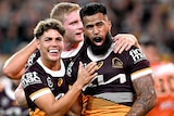Three Brisbane Broncos NRL players embrace as they celebrate a try.