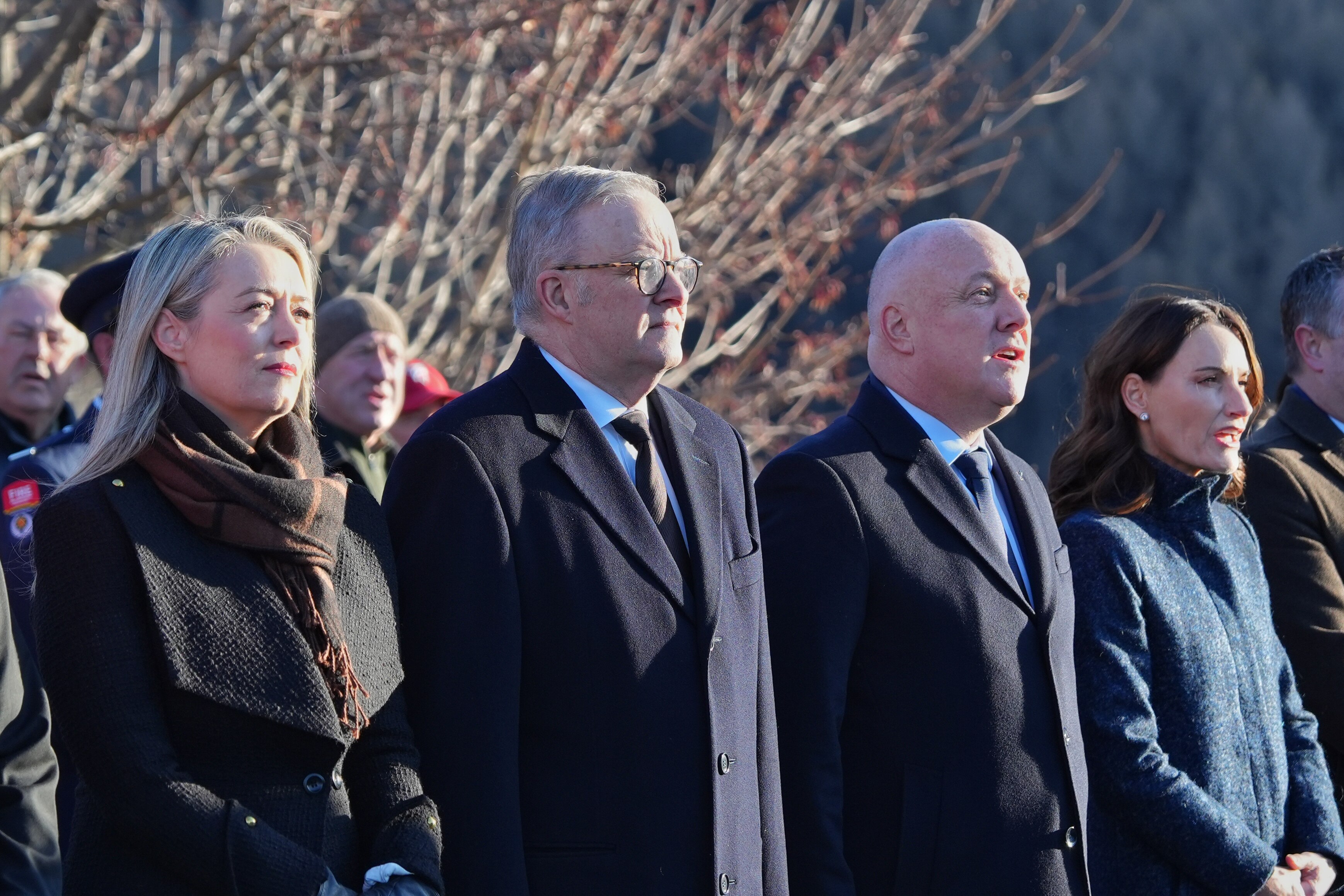 Albanese and Luxon stand with their partners outdoors.