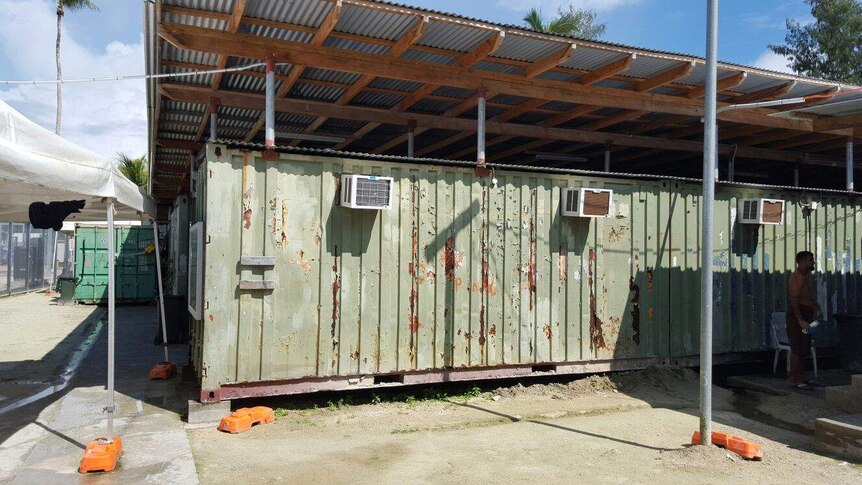 The rear of the Delta Compound on Manus Island: a run down green building with patches of rust.