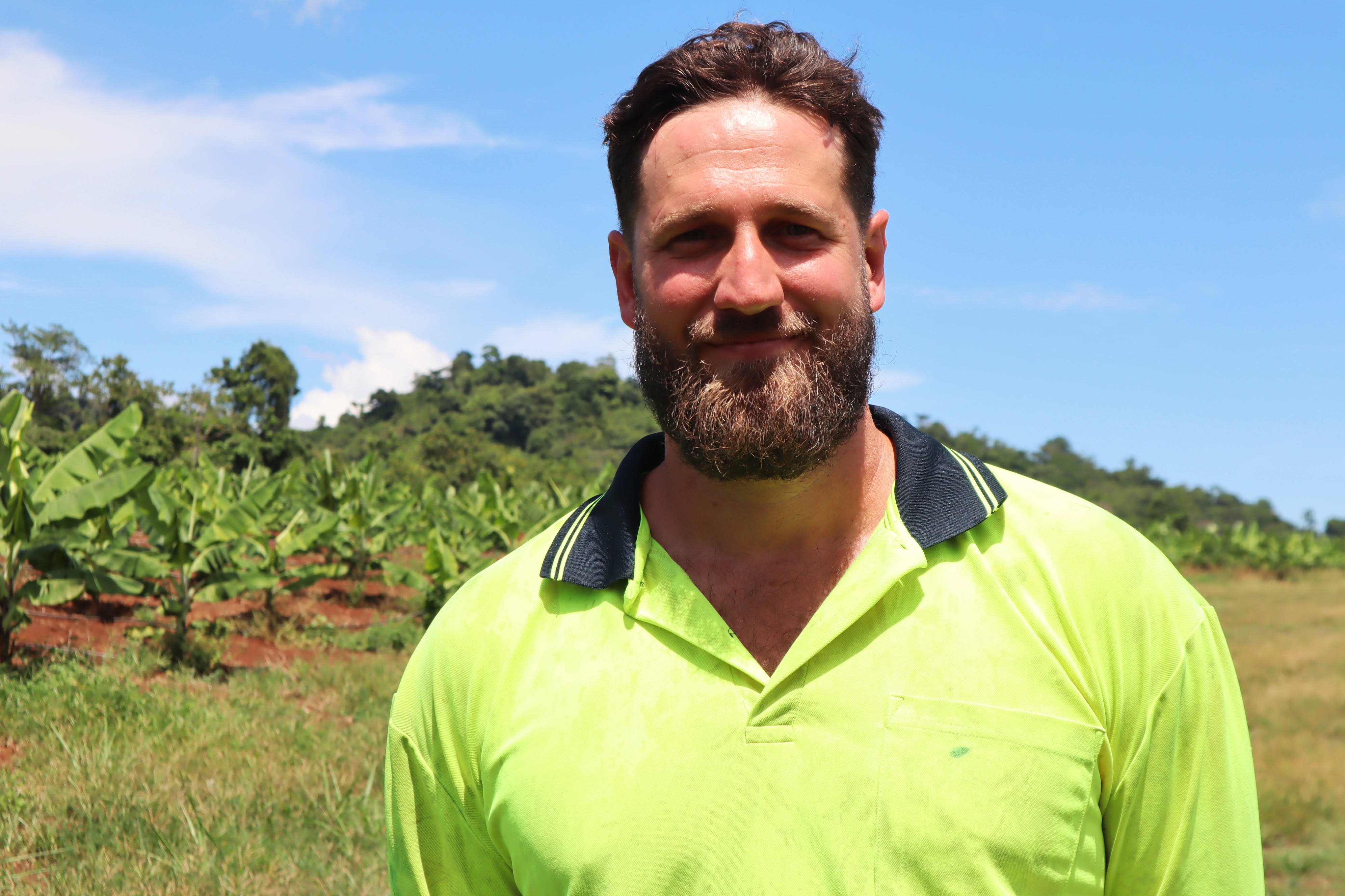 A farmer smiles in banana plantation.
