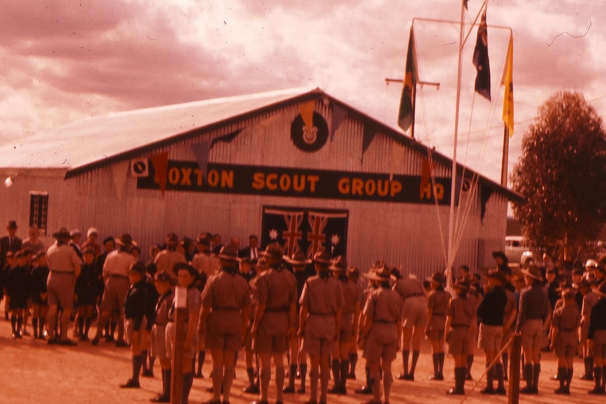 An old photo of children in scout uniforms standing in front of a large building that says Loxton Scout Group