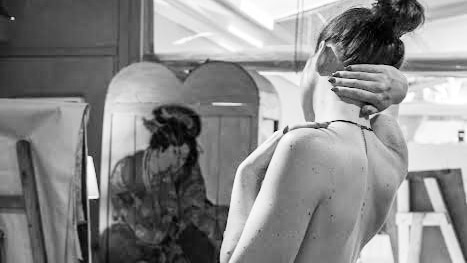 black and white shot of woman nude, from behind, in art studio