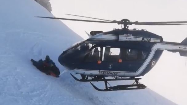 the helicopter lands for rescue next to the injured skier