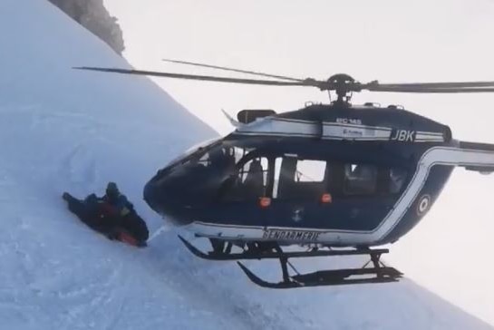 the helicopter lands for rescue next to the injured skier