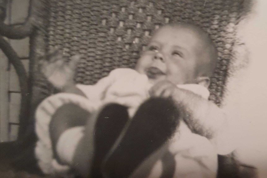 Black and white photo of a baby in a chair.