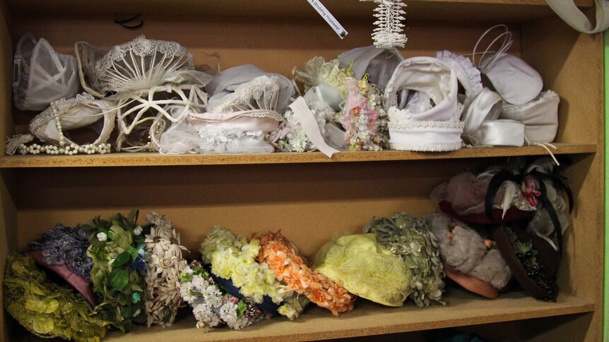1960s bridal hats on some wooden shelves.