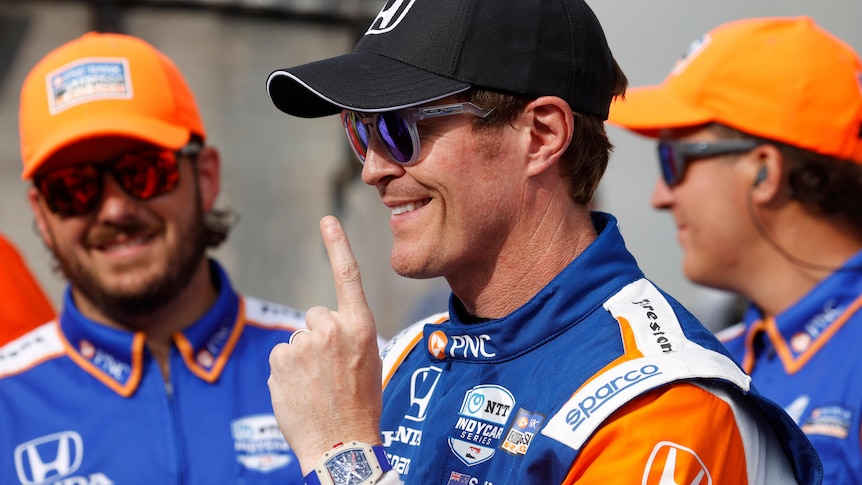 Scott Dixon smiles and holds up one finger